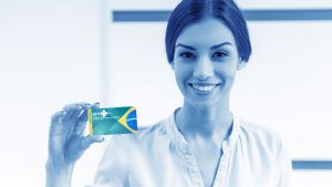 Foto de uma mulher sorrindo, segurando o cartão do SUS emitido pela internet.