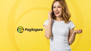 Foto de uma mulher branca, sorrindo e falando no celular. Ao lado o logo do PagSeguro.