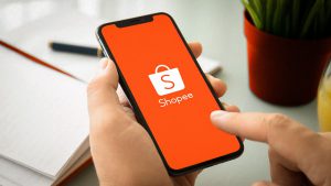 Imagem de uma mão segurando um celular com o aplicativo da Shopee aberto