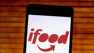 Imagem com celular em cima de uma mesa e com o aplicativo do ifood aberto.