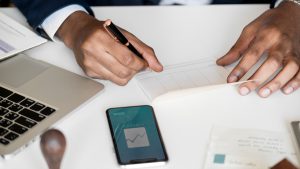 Homem assinando um documento, que representa um cheque caução.