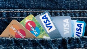 Cinco cartões de crédito, três Visa e dois Mastercard em um bolso de calça jeans.