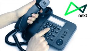 Imagem de uma mão discando em um telefone e, ao lado direito, o logotipo do banco next.