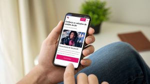 Pessoa segurando um celular, cuja tela mostra o site da BV Financeira.