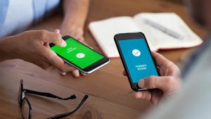Adultos realizando a Transferência Eletrônica de Valores (TEV) pelo aplicativo no celular