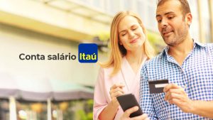 Na imagem está o logotipo da Conta Salário Itaú e, ao lado direito, um casal composto por um homem e uma mulher olhando para a tela de um celular.