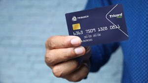 Foto de um homem segurando o cartão de crédito Tricard, do Tribanco.