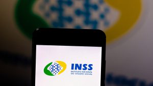 Foto de um celular, na tela o logo do INSS.