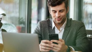 Homem utilizando o celular para acessar o Internet Banking do Banco Original