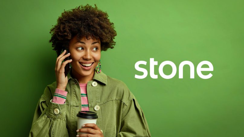 Na imagem está uma mulher com um celular no ouvido em contato com a Ton Telefone em um fundo verde, ao lado dela está a logotipo da Stone.